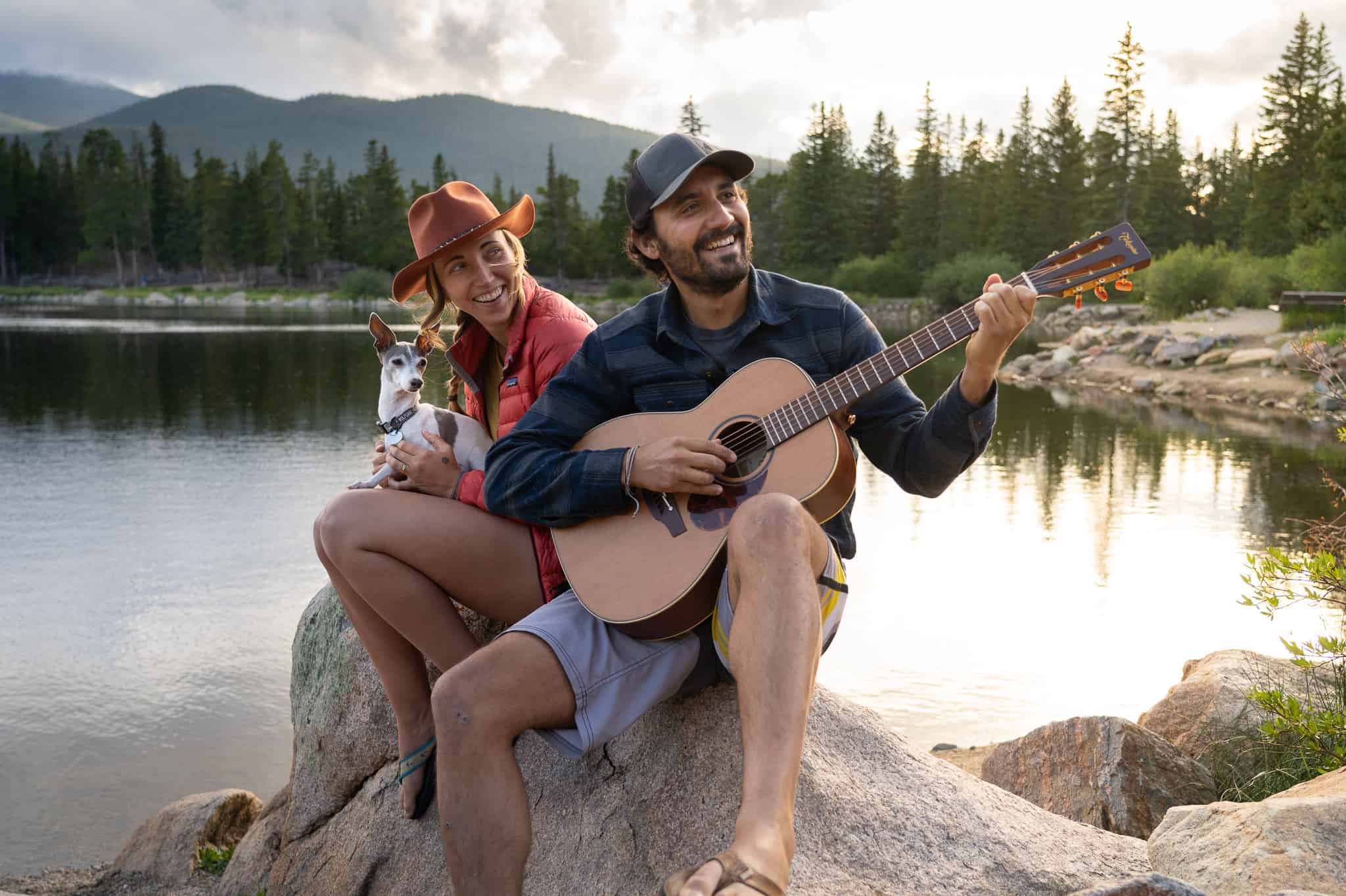 two people playing guitar on lake