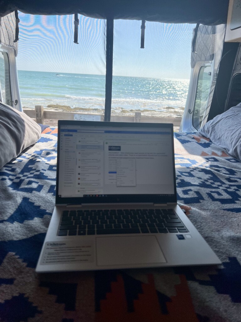 Open computer screen and van doors open overlooking water